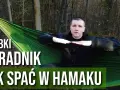 Mężczyzna w lesie pokazuje, jak prawidłowo wykonać mocowanie hamaka, by wygodnie spać w naturze.