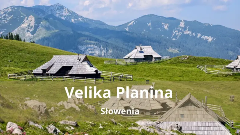 Tradycyjne drewniane domki pasterskie na zielonych wzgórzach Velika Planina w Słowenii, z majestatycznymi górami w tle.